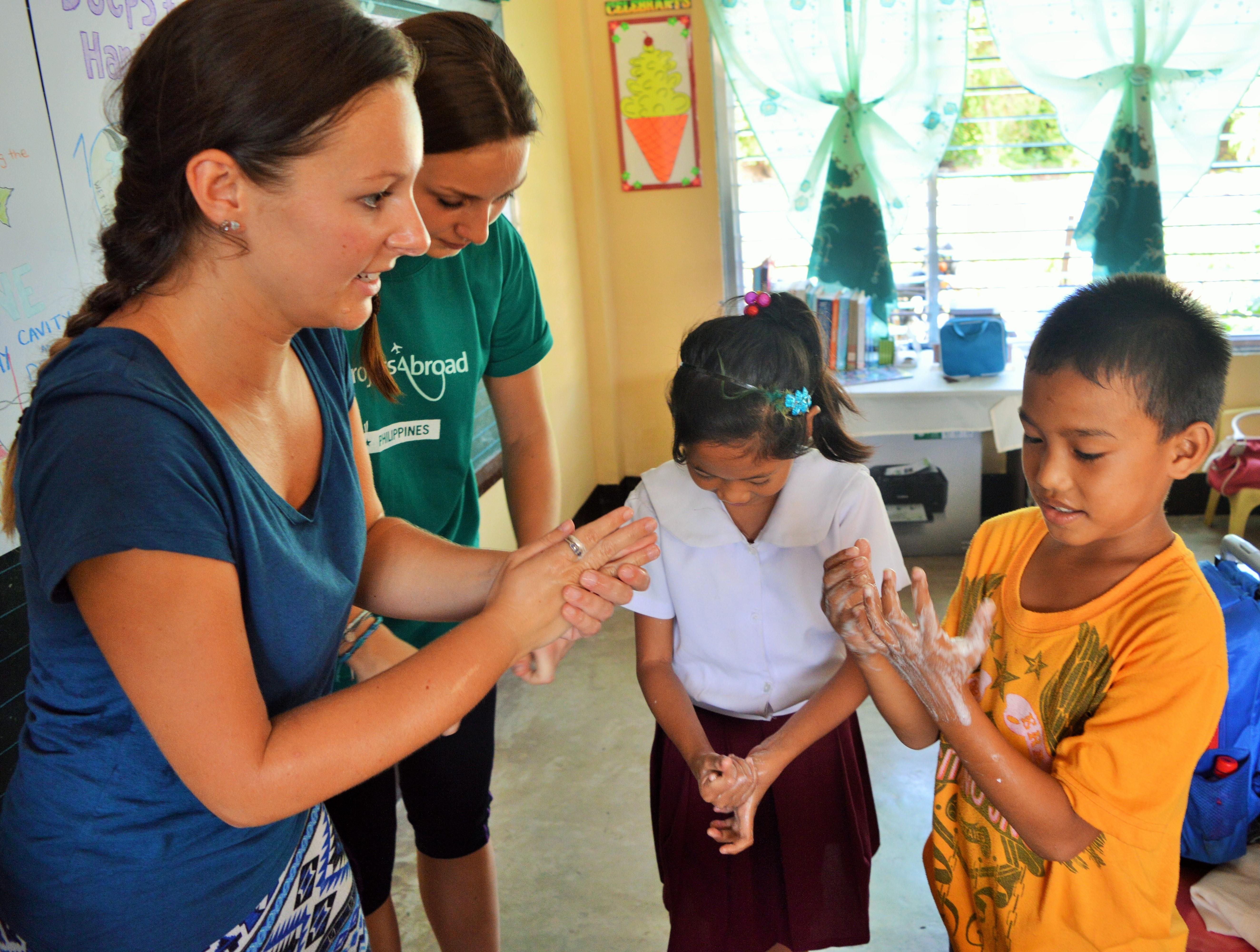 Projects Abroad volunteers teaching in the Philippines show their students how to wash their hands correctly Volunteers run a hygiene class for their students during their teaching work experience in the Philippines